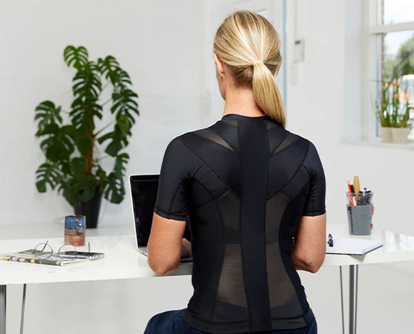 Frau mit Anodyne Posture Shirt am Schreibtisch